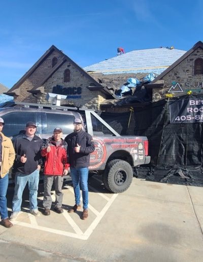The Belter Roofing Commercial Team standing in front of a commercial roof replacement in Oklahoma.