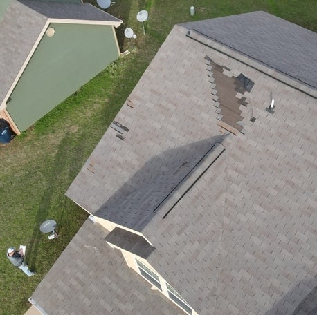 Belter Roofing inspecting an Oklahoma roof to see if it needs a residential roof replacement.