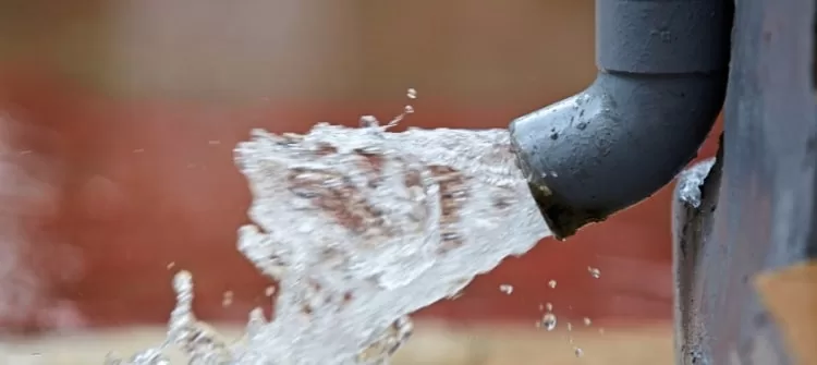 An Oklahoma gutter discharging water from a roof.